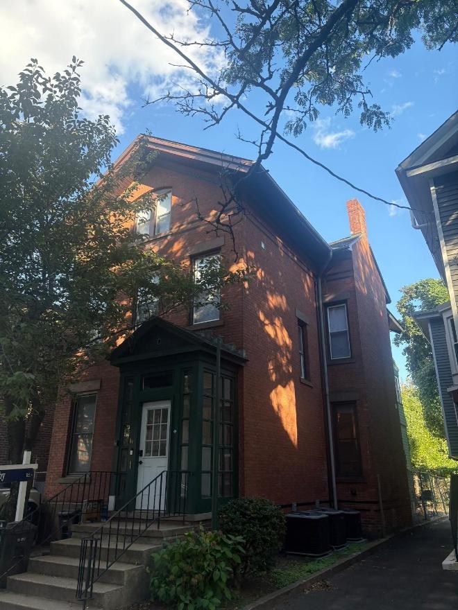 Image 2. West (front) façade of 115 Howe Street from Howe Street, showing the steep gable with its bargeboard and corner brackets, the stone lintels and the dark green glazed vestibule.