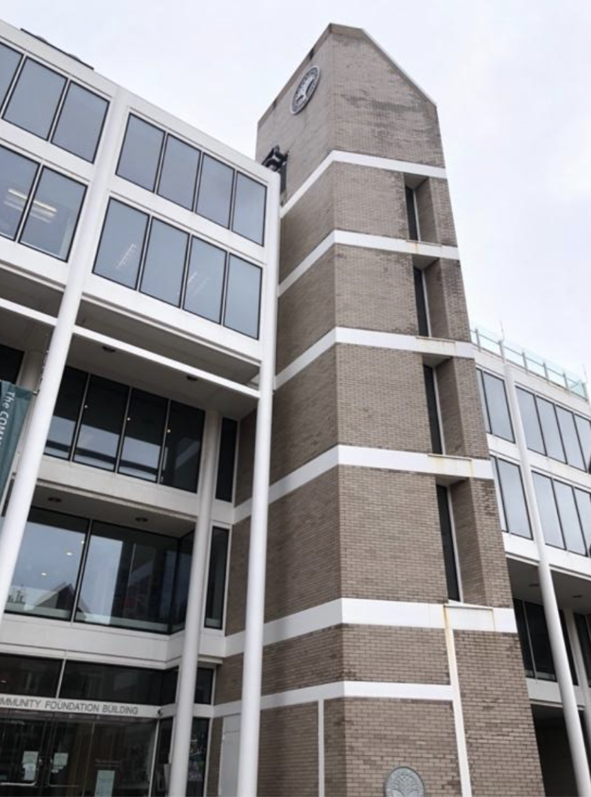 View of the brutalist-style tower on the right side of the building, with a view of both of the “New Haven Foundation Building” plaques.