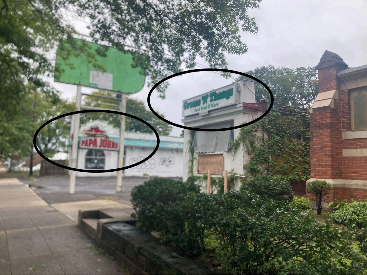 View of the outside of the building from the sidewalk in front of St. Luke’s Church. Note branding that remains from Papa John’s and Greens ‘N’ Thangs.