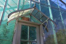 Image #2. Edgerton Park greenhouse housing the Sarah T. Crosby Conservatory and the  G.R.O.W.E.R.S. program. Featuring tropical plants and a main entrance constructed from cut  stone with crenelated detailing. 